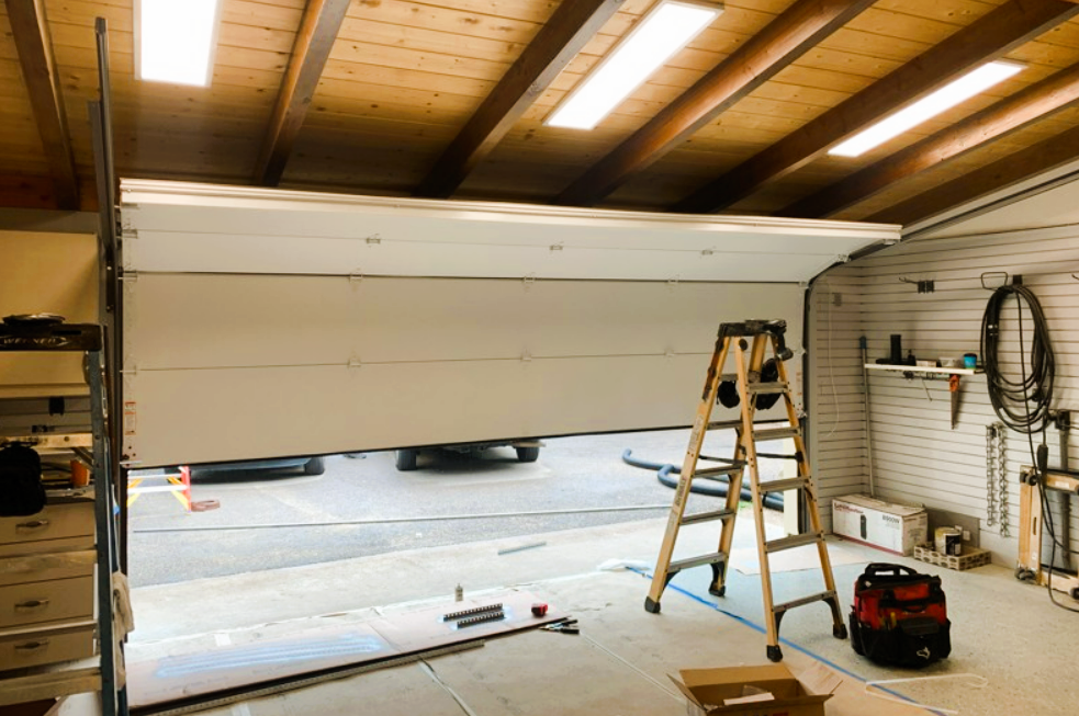 Technician performing garage door cable repair and track alignment in Lewis Center OH