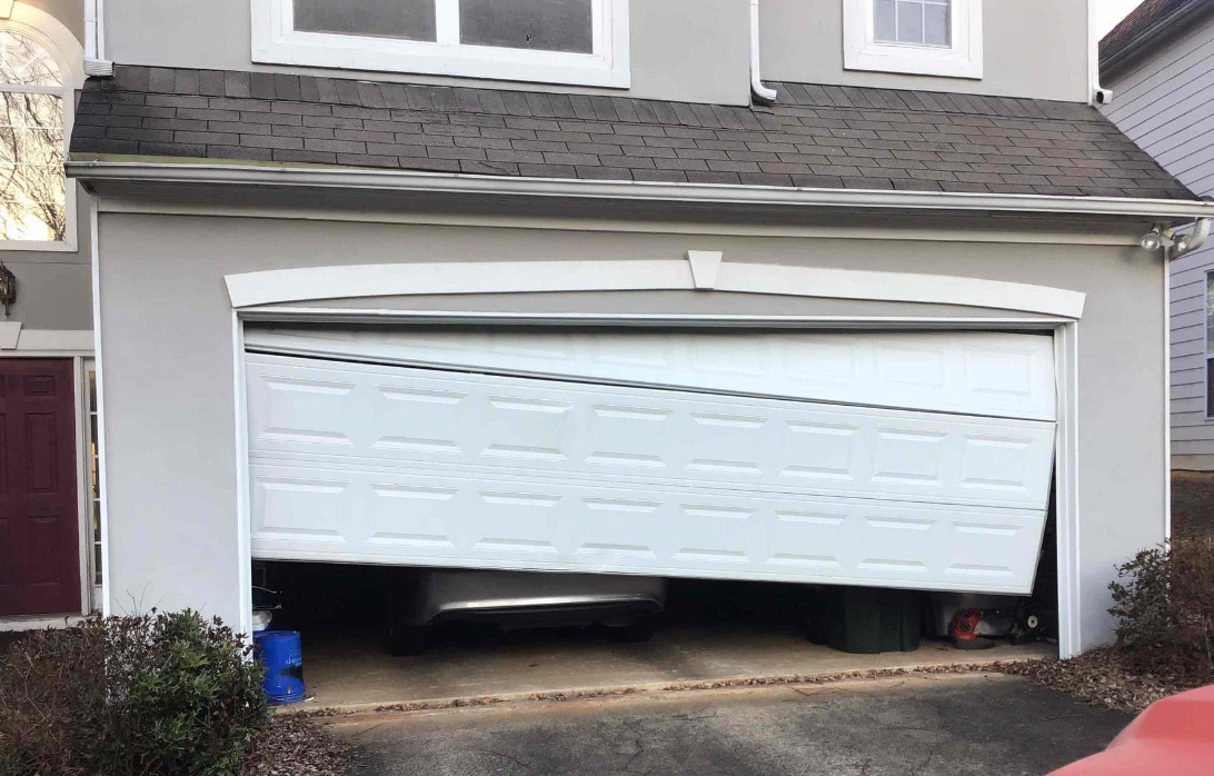 Certified technician safely resetting a crooked and off-track residential garage door in Sunbury, Ohio
